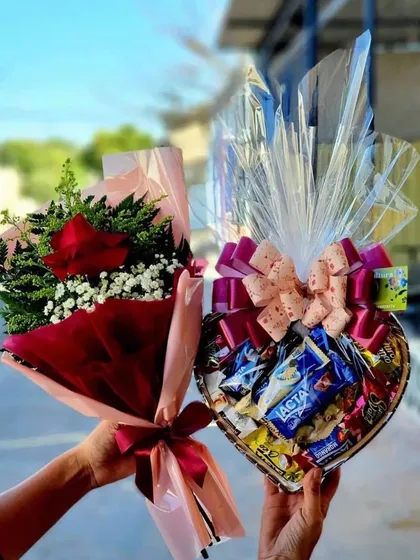 A perfect gift combination of a fresh red rose bouquet and a heart-shaped basket filled with assorted chocolates.