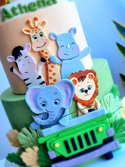 A detailed shot of the fondant animals riding in a jeep on the safari cake.