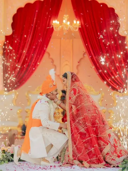 A classic Bollywood moment. The groom gets down on one knee during the varmala, with sparklers going off in the background for that extra touch of drama.