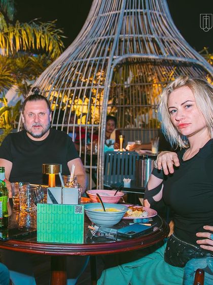 A couple enjoying food and drinks in the outdoor seating area.