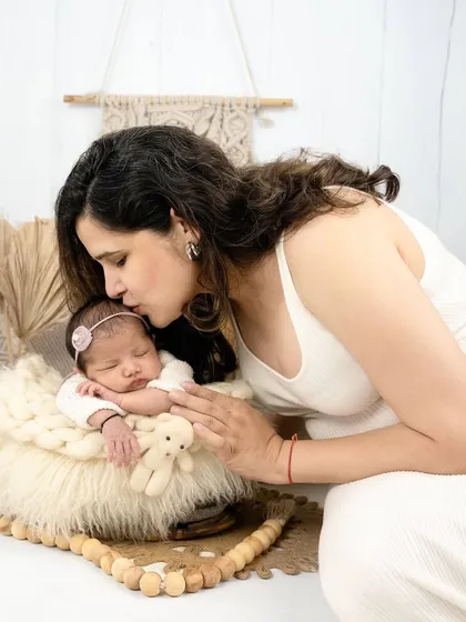 A mother's gentle kiss for her sleeping baby, set in a cozy, boho-themed corner of my studio. This image combines the warmth of family love with a stylish, natural aesthetic.