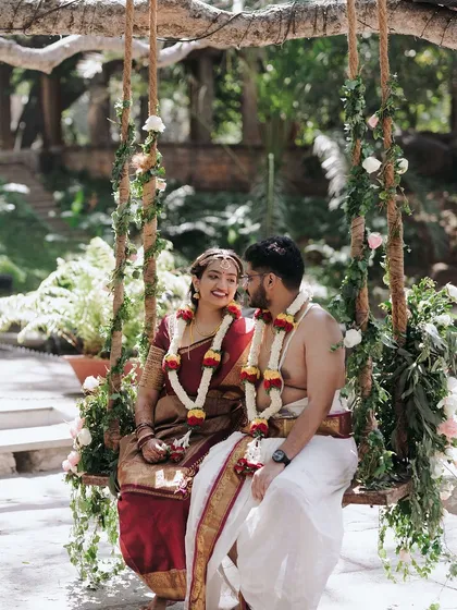 A classic portrait on the floral swing. This is a favorite spot for couples to capture a moment of shared joy, surrounded by the beauty of our ancient trees.
