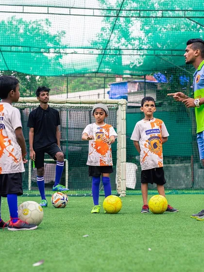 A coach giving instructions to a group of young, attentive football players. I believe in clear communication and personalized feedback.