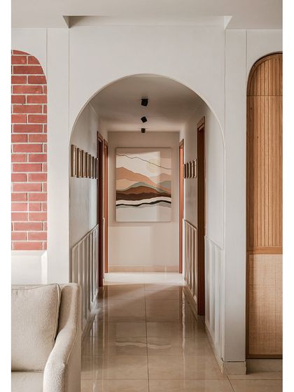 This corridor was designed as a visual journey, with arches framing the path to the bedrooms. A custom artwork at the end creates a focal point, while micro-topping textures add depth and connect the spaces.