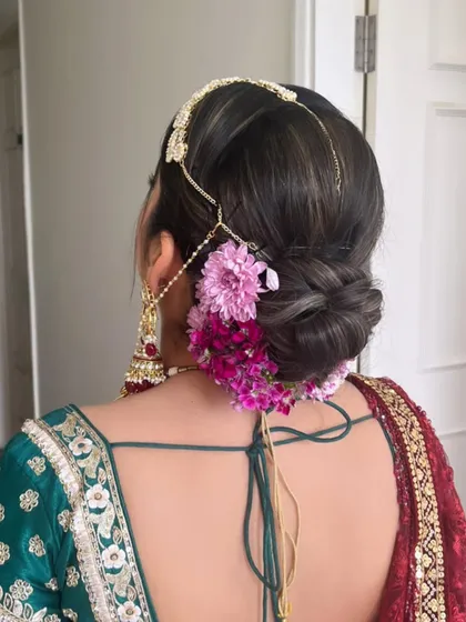 Another angle of this beautiful floral bun, showing the delicate matha patti accessory. This is a perfect look for a traditional wedding ceremony.