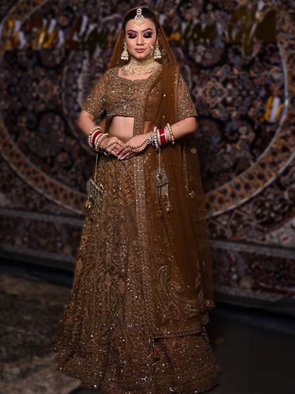 For the bride who loves glamour. This deep brown bridal lehenga is fully embellished with sequins and threadwork, creating a rich and luxurious look for a winter wedding.