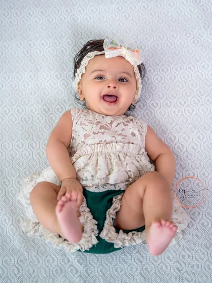 A happy baby on her back, kicking her feet with joy. These playful, natural poses make for the best milestone photos.
