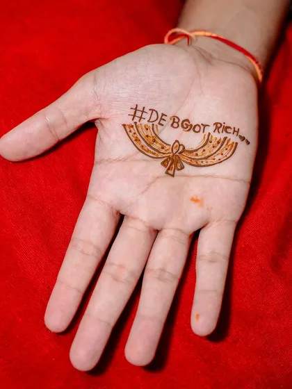 We can get creative and personal with groom mehandi too. This design features the couple's wedding hashtag, #DEBGOTRICH, making it a fun and modern way for the groom to be part of the tradition.