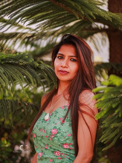 A beautiful portrait framed by the natural branches of a tree. The composition feels organic and highlights her connection to the environment.