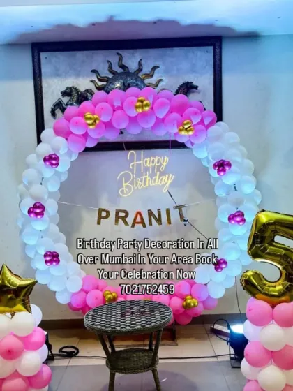 A pretty pink and white balloon ring with the birthday person's name, Pranit. The large number '5' foil balloon and star accents complete this personalized setup.