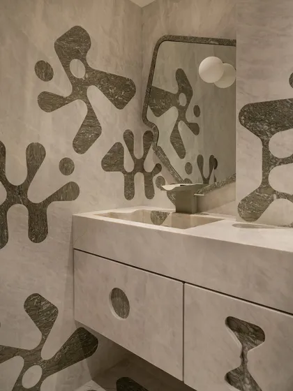 We pushed the boundaries of material and geometry in this powder bathroom. The walls, integrated vanity, and even the sculptural sink basin feature a bold, amoeba-like pattern inlaid in contrasting marble. This required immense precision from our artisans to carry the inlay seamlessly from horizontal to vertical surfaces.