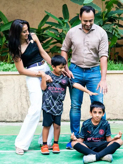 A fun, candid family photo taken during an outdoor football-themed birthday party.