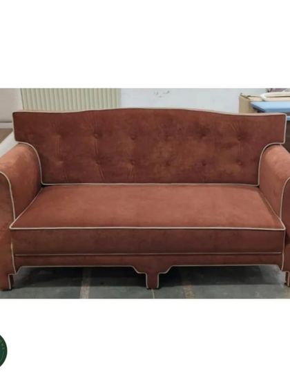 A workshop shot of the classic terracotta sofa, allowing a clear view of its form and construction before being placed in a home.