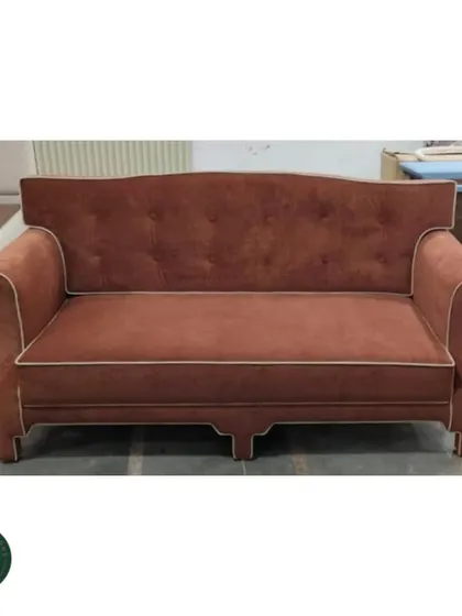 A workshop shot of the classic terracotta sofa, allowing a clear view of its form and construction before being placed in a home.
