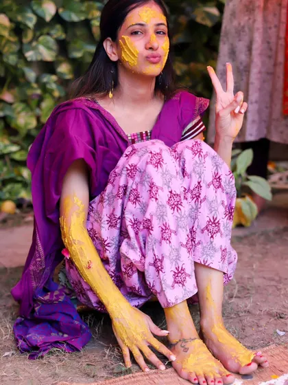 A fun and playful shot of the bride flashing a peace sign during her Haldi. This photo perfectly captures her personality and the joyful, relaxed vibe of the ceremony.