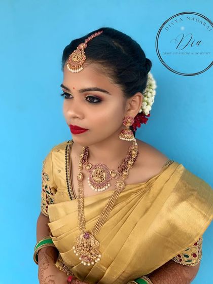 A stunning traditional look on a beautiful model. The golden Kanjeevaram saree is paired with a classic red lip, smoky eyes, and an elegant updo with jasmine flowers.