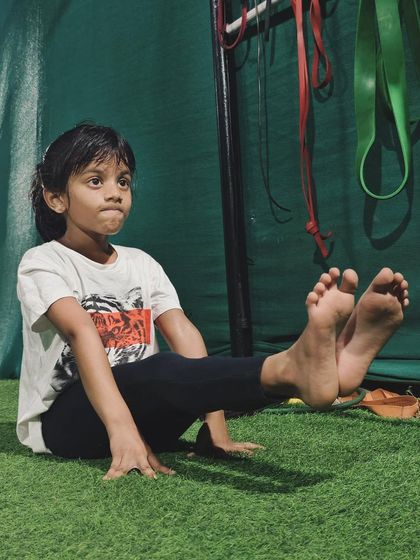 Focus and determination in her eyes. This young athlete is mastering the L-sit, a fundamental calisthenics skill that builds immense core and upper body strength.