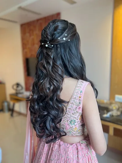 A classic half-updo with a braided detail and scattered pearls.