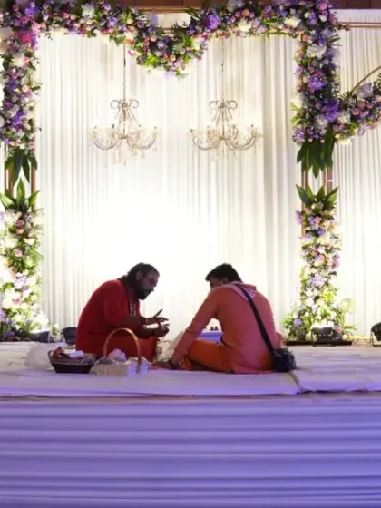 The main stage setup where the Roka ceremony rituals took place, framed by arches of purple and pink flowers and delicate chandeliers.