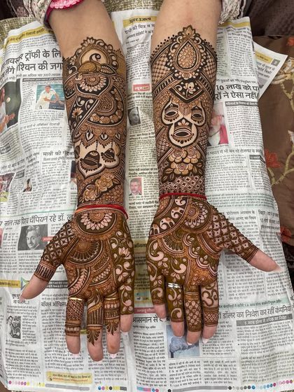 A clear shot of the full bridal mehandi, showcasing the variety of motifs used, including peacocks and masks.