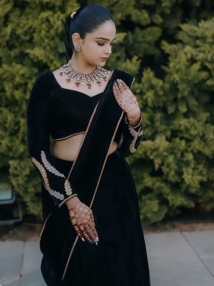 The rich texture of the black velvet is the star of this outfit. The blouse features subtle embroidery on the sleeves for a touch of detail.