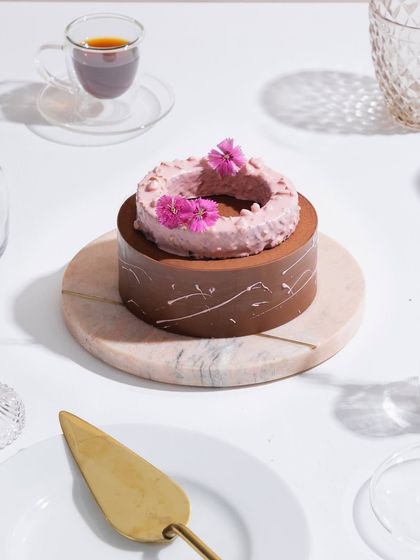 A full view of our Belgian Chocolate and Raspberry Entremet, served on a marble platter. Every bite is a mood.