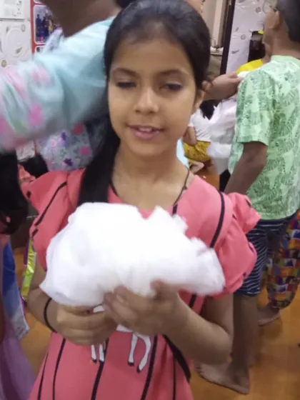 A student holding up her fluffy white cloud craft, made from cotton. Simple crafts like these are perfect for our youngest artists.
