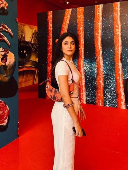 Our custom Selena in Artichoke Red, spotted at an art gallery. The bag itself is a piece of wearable art, adding a splash of color to a neutral outfit.