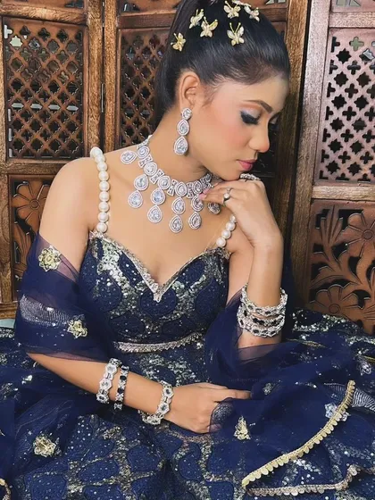 A model in a navy blue gown wearing a modern American Diamond necklace with pearl drops. This set is perfect for a glamorous evening event.