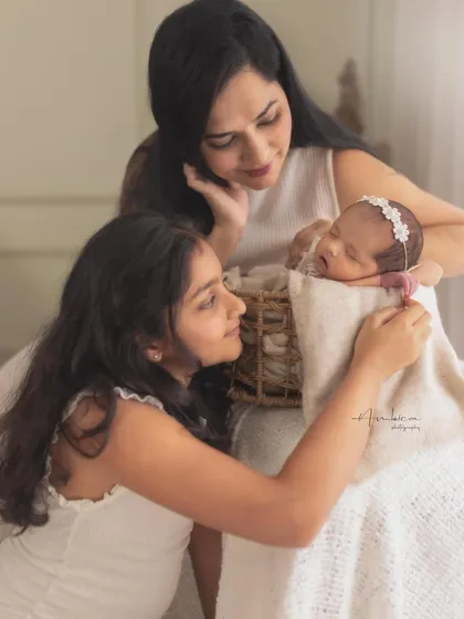 Three generations of love. A mother and older sister look lovingly at the newest member of their family, a beautiful story of their bond.