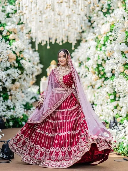A joyful twirl in front of a magnificent floral arch. The makeup is designed to be picture-perfect, ensuring the bride looks stunning in her wedding photos.