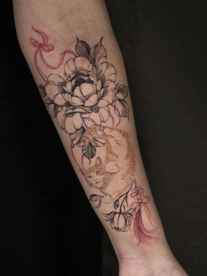 A delicate and beautiful illustrative piece. This tattoo combines a realistic color portrait of a ginger cat with fine-line black and grey peonies, all tied together with a flowing red ribbon.