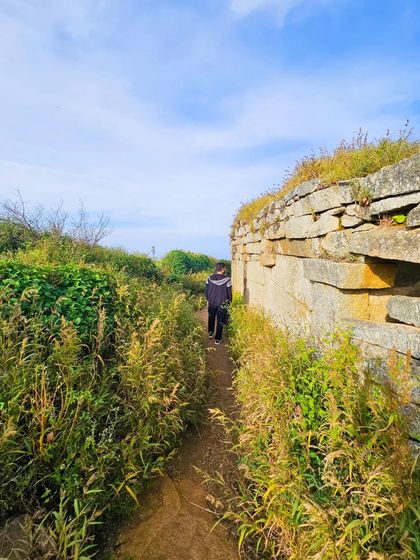 Exploring the ancient fort ruins along the Skandagiri trail. The path is lined with history and lush vegetation.