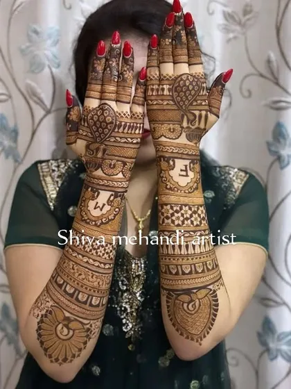 This design showcases the couple's initials 'S' and 'M' prominently on the back of the hands, surrounded by heart shapes and traditional patterns.