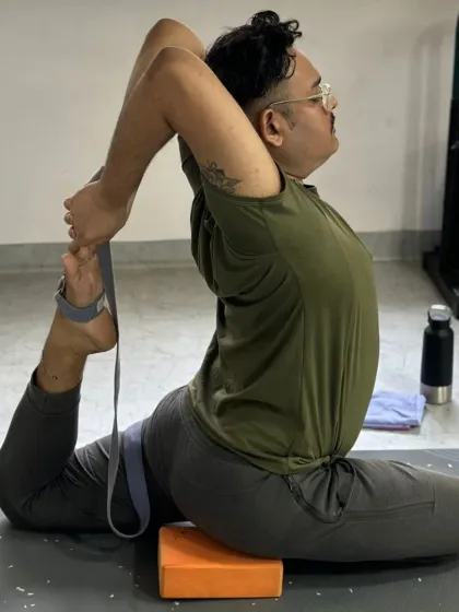 This student uses a block and a belt to work towards Eka Pada Rajakapotasana, demonstrating the smart use of props to achieve challenging hip openers.