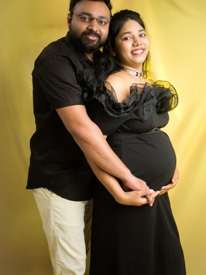 I love playing with color in my studio. This happy couple portrait uses a warm yellow backdrop that contrasts beautifully with their black outfits, creating a vibrant and joyful memory of their pregnancy.