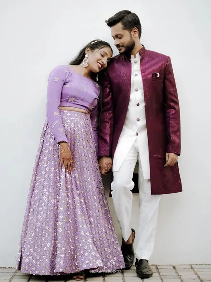 A sweet moment between the couple, the bride resting her head on the groom's shoulder, both dressed elegantly for their reception.
