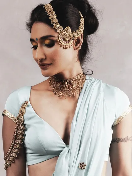 For this traditional jewellery shoot, I created a soft, golden wash on the eyes to complement the antique gold jewellery. The clean, elegant updo and flawless skin finish give the look a modern yet timeless feel for any ethnic wear campaign.