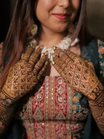 A bride's mehandi is a key part of her overall look. This full-hand jaal pattern complements her heavy bridal attire perfectly, showing how the deep stain of our natural henna stands out in wedding photos.