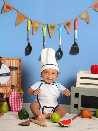 This baby chef is surrounded by fresh fruits and vegetables, ready to cook up a storm. Themed sitter sessions are a great way to capture their curious nature.