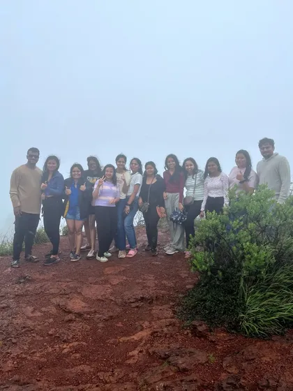 A group of trekkers enjoying the misty weather at a viewpoint in Chikmagalur.