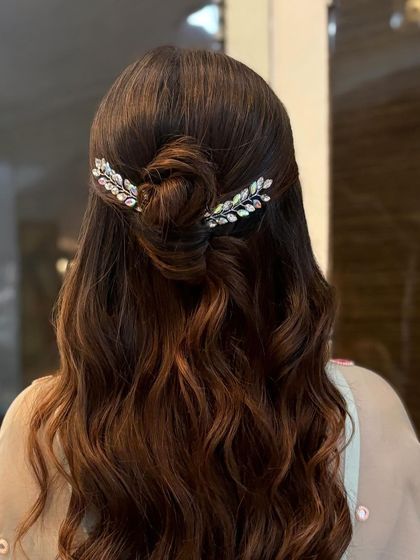 A close-up of the half-up bun with crystal leaf accessories. The detail of the bun and the placement of the clips are key to this elegant style.