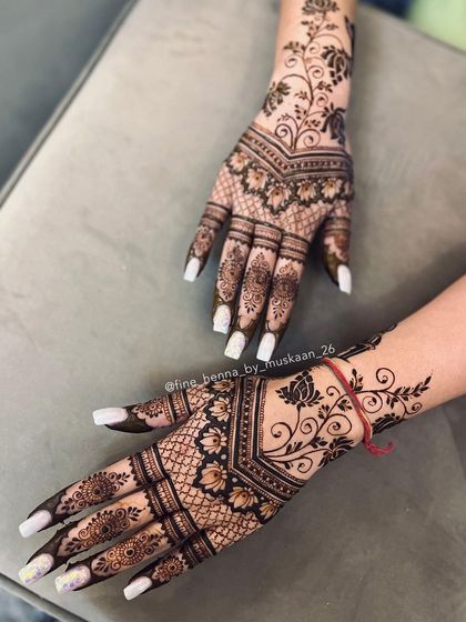 A modern back-of-hand design combining a net pattern with a floral vine that trails up the arm.