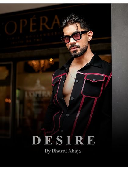 A close-up portrait in the black and red piped jacket. The tinted glasses and confident expression complete the look of modern allure.