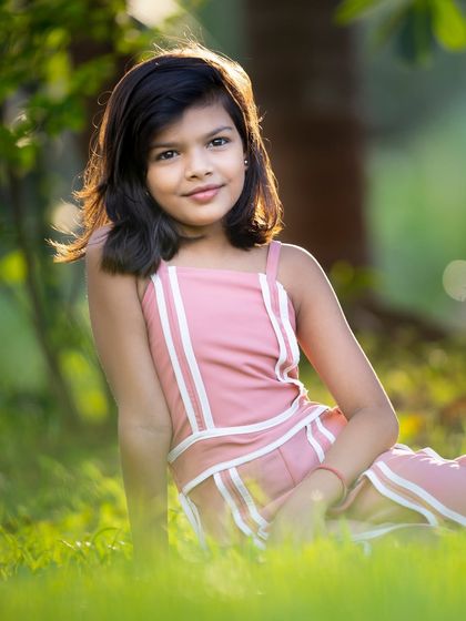 A beautiful portrait of a young girl enjoying the golden hour light in a park. The soft, natural lighting creates a warm and serene mood, perfect for outdoor child photography.