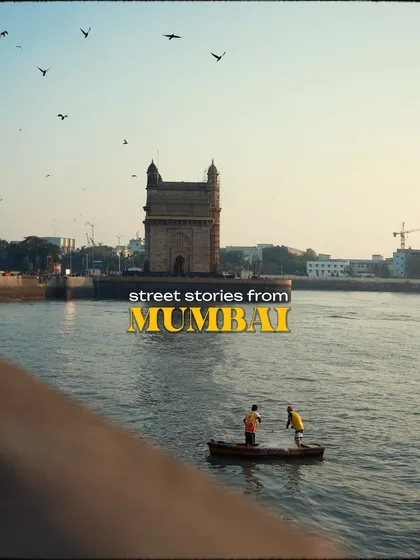 An image titled "Street Stories from Mumbai." It features two fishermen in a small boat before the Gateway of India, a perfect summary of the city's blend of livelihood and landmarks.