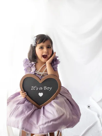 The excitement of a big sister-to-be. Including siblings is a wonderful way to capture the entire family's anticipation and joy for the new arrival.