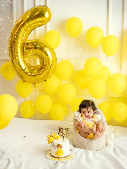 Another adorable shot from the half-birthday celebration, with the baby sitting up happily next to her cake.