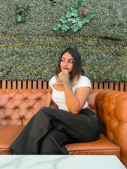 Thinking about what to eat on a cheat day. I'm wearing a simple white cutout top with wide-leg black pants, a comfortable and stylish casual look.