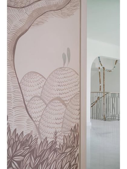 A hand-painted mural adds a touch of artistry to this hallway at Eden House, which leads out to a stunning staircase and outdoor area.